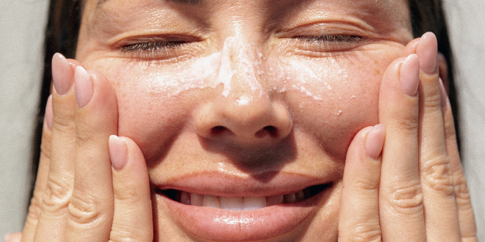 A woman touching her face whilst smiling